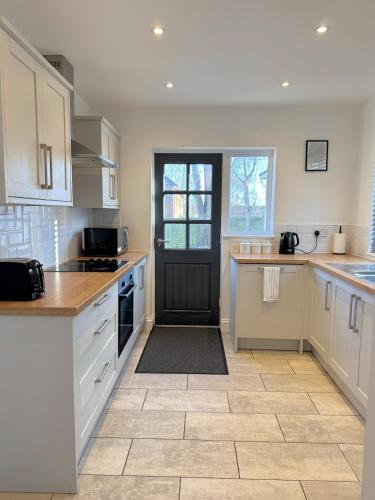 a kitchen with white cabinets and a black door at Grey haven - Central & 5 min from Southmead Hospital in Bristol