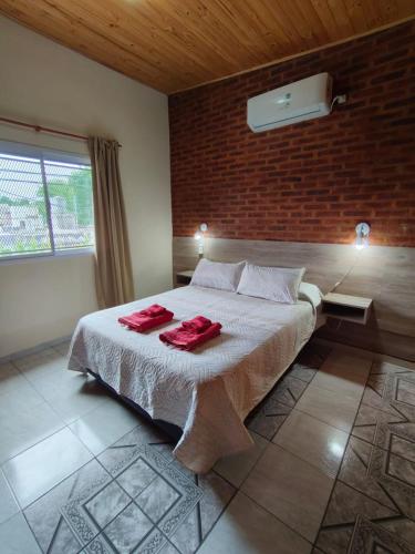 a bedroom with a bed with two red towels on it at 4 Estaciones in Pergamino