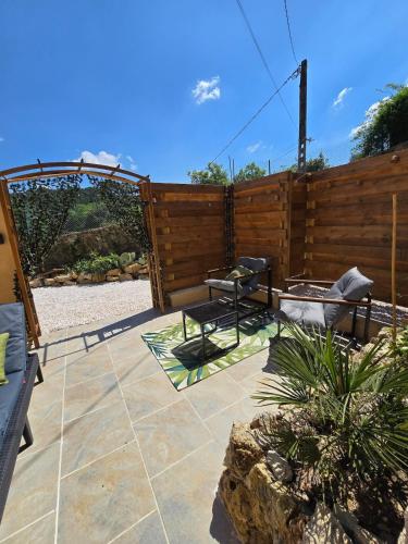 a patio with a fence and a table and chairs at Mini Loft à la campagne La BA-LINE in Entrecasteaux
