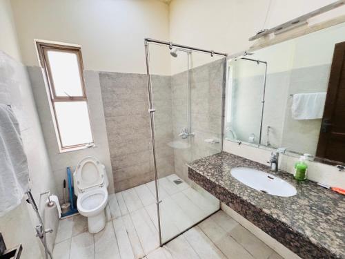 a bathroom with a toilet and a sink and a shower at Alpine lodges in Islamabad