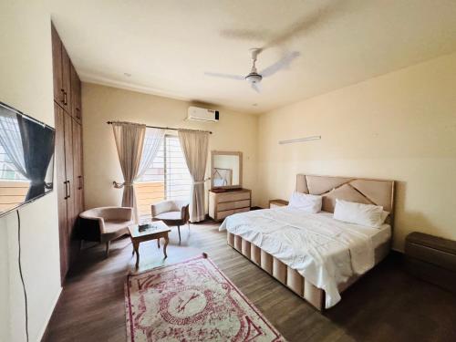 a bedroom with a bed and a chair and a table at Alpine lodges in Islamabad