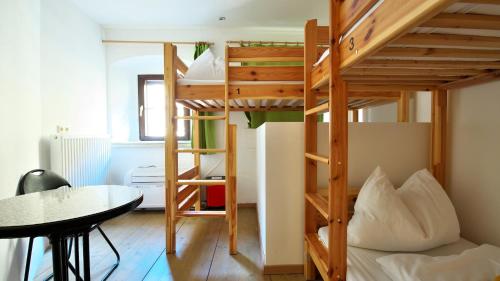 a room with a bunk bed and a table at Hostel Bad Goisern in Bad Goisern