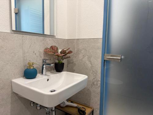 a bathroom with a white sink and a mirror at NEU Golden Apartment Zentrum Goldstadt Pforzheim Schlössle in Pforzheim