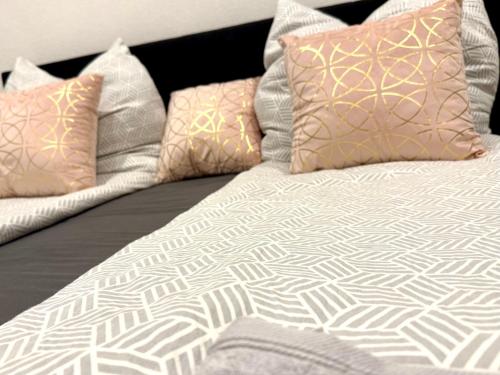 a bed with four pillows on top of it at NEU Golden Apartment Zentrum Goldstadt Pforzheim Schlössle in Pforzheim