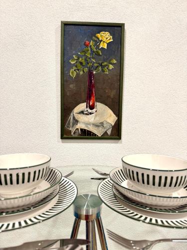 a painting of a vase on a table with plates at NEU Golden Apartment Zentrum Goldstadt Pforzheim Schlössle in Pforzheim