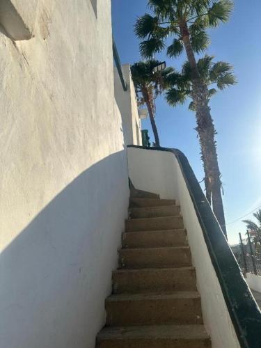 a staircase leading up to a building with palm trees at Tuneras Sunset Puerto Rico Apartment in Mogán