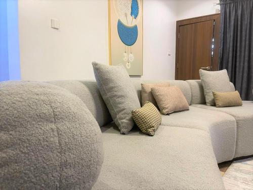 a couch with pillows sitting in a living room at Imperio Apartments in Abuja