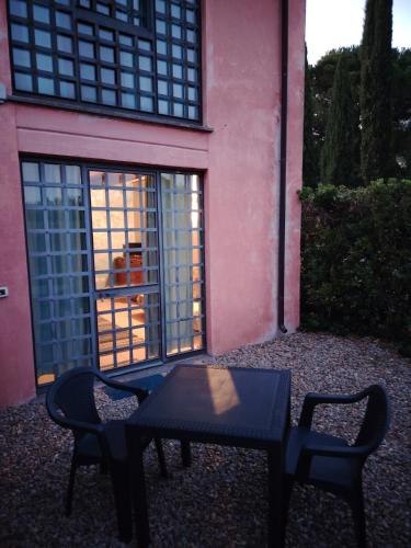 a table and chairs in front of a pink building at Agriturismo Corte Sakura in Montefiascone