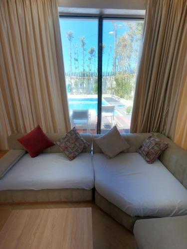 a living room with a couch and a large window at villa vue sur mer avec piscine in Al Houara