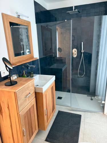 a bathroom with a sink and a shower with a mirror at Appartamento PELER - Residenza OLIVEA in Riva del Garda