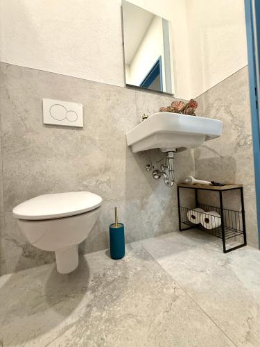 a bathroom with a white toilet and a sink at NEU Golden Apartment Zentrum Goldstadt Pforzheim Schlössle in Pforzheim