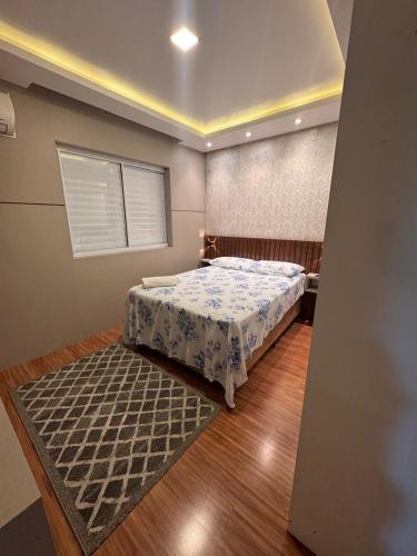 une chambre avec un lit et un tapis dans l'établissement Apto no Coração de Criciúma, à Criciúma