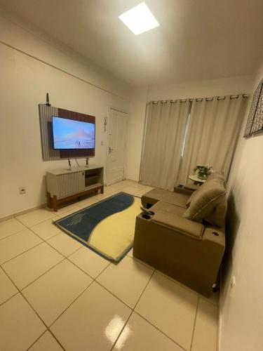 un soggiorno con divano e TV a schermo piatto di Cond Alf Costa ap 01 a Belém
