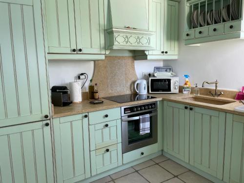 a kitchen with white cabinets and a stove top oven at Waterfront Villa with private pool in Melissaki