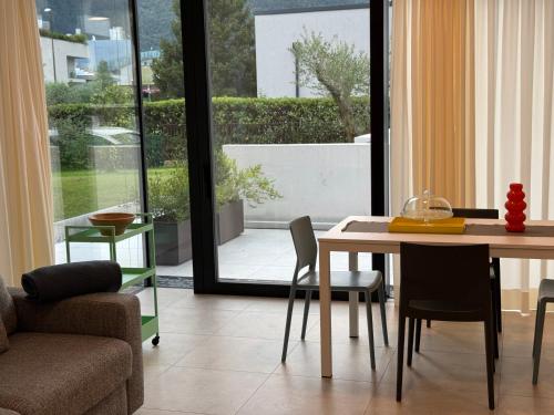 a living room with a table and chairs and a window at Appartamento PELER - Residenza OLIVEA in Riva del Garda