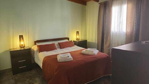 a bedroom with a bed with two towels on it at hena apart 3 in Esquel