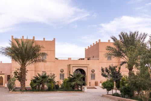 メルズーガにあるRiad Serai Merzougaの前にヤシの木がある建物