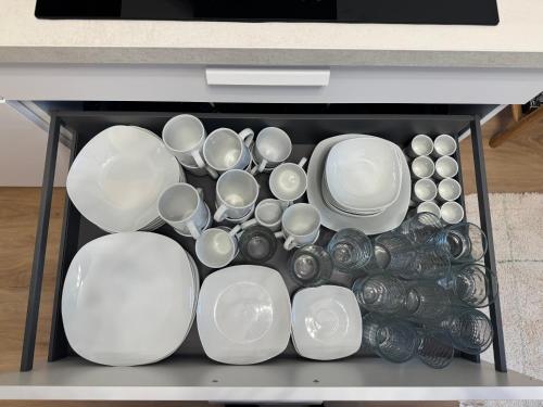 a bunch of white plates and bowls in a drawer at City-Apartment am Aubachufer in Schwerin