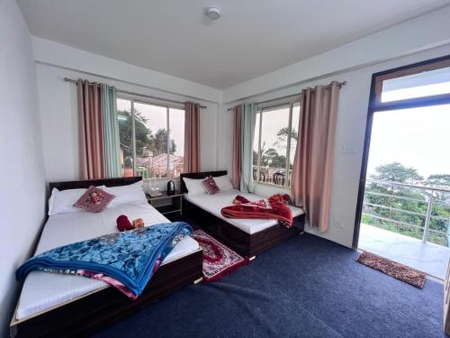 Un dormitorio con dos camas y una gran ventana. en Nimbus Soulstay, en Kalimpong