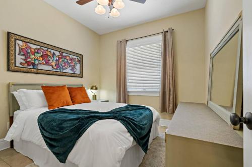 a bedroom with a bed with orange pillows and a window at Heart of Hyde Park Tampa/Parking/Netflix/Gym in Tampa