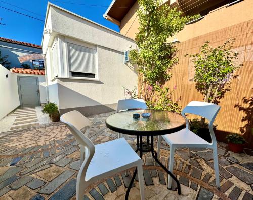 a patio with a table and chairs on a brick patio at Apartment 'Avlija' in Mostar