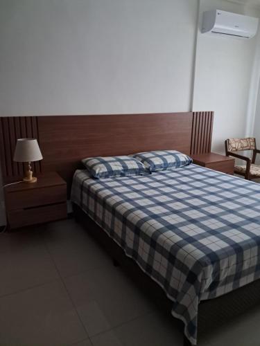 a bedroom with a bed with a blue and white checkered blanket at Apartamento de 1 dormitorio para persona sola o pareja in Santa Cruz de la Sierra