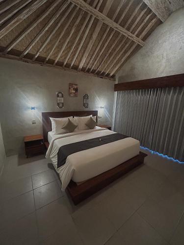 a bedroom with a large bed in a room at QINARA, Guesthouse Close to Diamond Beach, Nusa Penida in Polilit