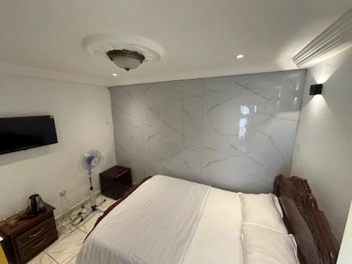a bedroom with a bed and a marble wall at Luxury Villa AC Ensuite Room 8 in Limbe