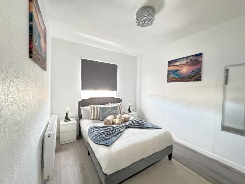 a bedroom with a bed in a white room at Spacious 2BR Home by Portobello Beach in Edinburgh