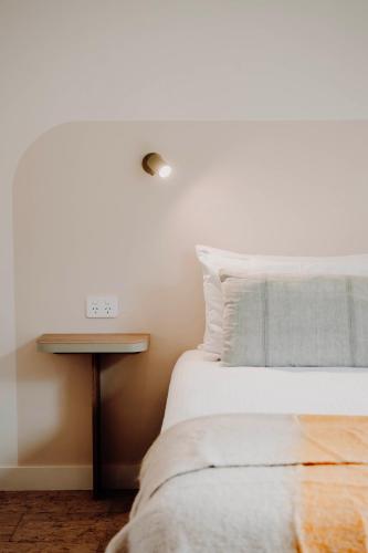 a bedroom with a bed and a nightstand next to a bed sidx sidx sidx at The Cudgee at Mudgee in Mudgee