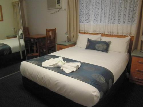 una camera d'albergo con un letto e asciugamani di Poet's Recall Motel a Gundagai
