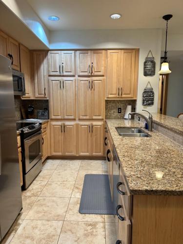 a large kitchen with wooden cabinets and a sink at Coeur d Alene Riverstone Retreat in Coeur d'Alene