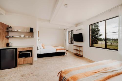 a bedroom with two beds and a large window at The Cudgee at Mudgee in Mudgee