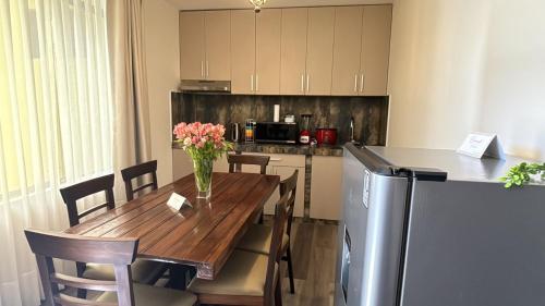 a kitchen with a wooden table with a vase of flowers on it at Pascana Hotel in Chivay