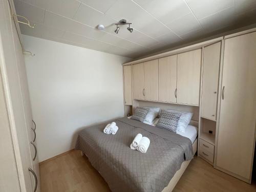 a bedroom with a bed with two towels on it at Bungalow-32-100-Schritte-bis-zum-Meer in Staberdorf