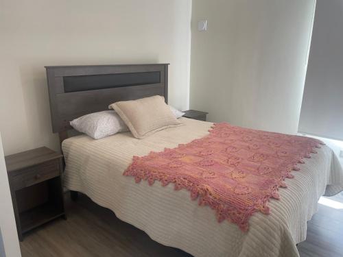 a bedroom with a large bed with a red blanket at Arriendo depto en La Serena condominio Firenze in La Serena