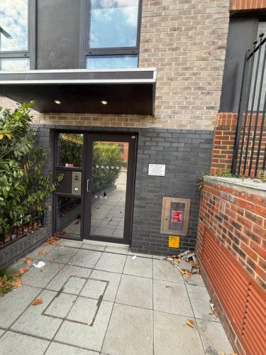 un ingresso a un edificio in mattoni con porta a vetri di Spacious Flat for Professional a Slough