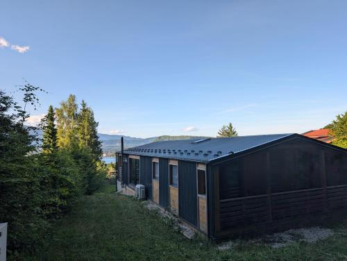 a small black building in the middle of a yard at Ferienhaus Enzo in Oberaichwald