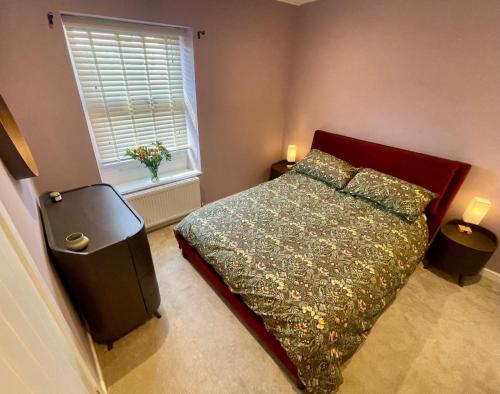 a bedroom with a bed and a window at Globe Cottage in Glastonbury