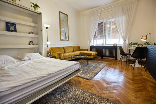 a bedroom with a bed and a living room at Piac 16 apartman a belváros szívében in Debrecen