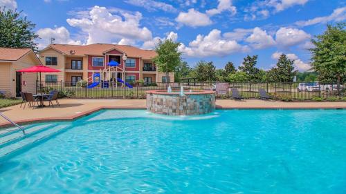 a large swimming pool in front of a house at Magnolia Hideaway 1BD-1BA - Gym, Pool, BBQ Grill in Tupelo