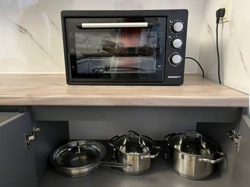 a toaster oven with pots and pans on a counter at Toon 33 in Koghb