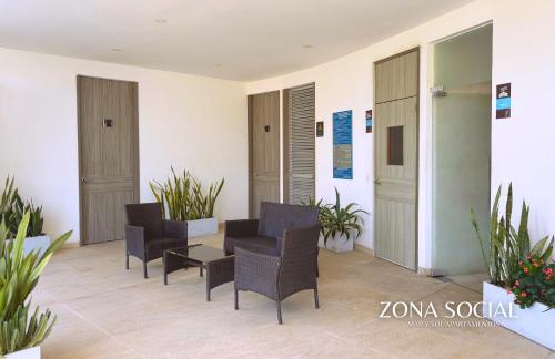 a waiting room with chairs and a table and plants at APARTAMENTO VISTA AL MAR WIND 906 in Gaira