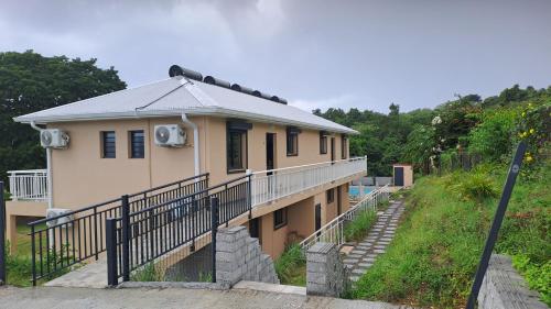 una casa en una colina con una valla delante en La Kay Fyfy, en Saint-Pierre