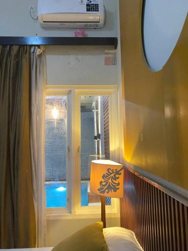 a lamp sitting next to a window in a room at eHouse in Banyuwangi