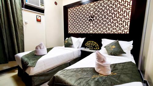 two beds in a hotel room with towels on them at فندق سمو العرب 