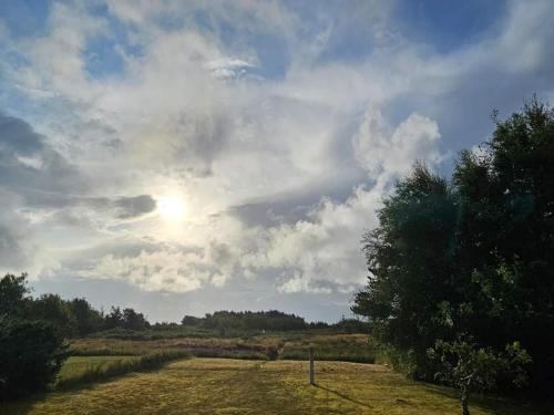 a cloudy sky with the sun in a field at Charming Family Retreat - By Traum Ferienwohnungen in Hals