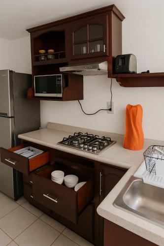 a kitchen with a stove top oven next to a sink at House with pool, near the beach - Casa con alberca, cerca de playa in Mazatlán