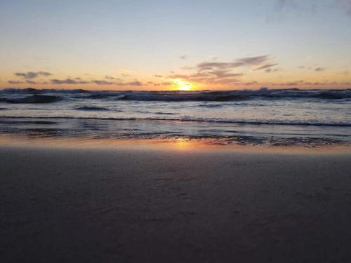 a sunset on a beach with the ocean at 6 person holiday home in Brovst-By Traum in Brovst