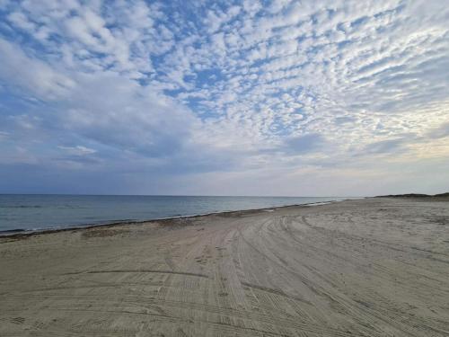 a dirt road on the beach under a cloudy sky at 2 person holiday home in Brovst-By Traum in Brovst